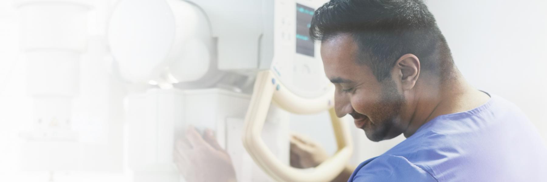 Technician using CT scanner